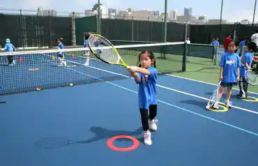 girl learning tennis